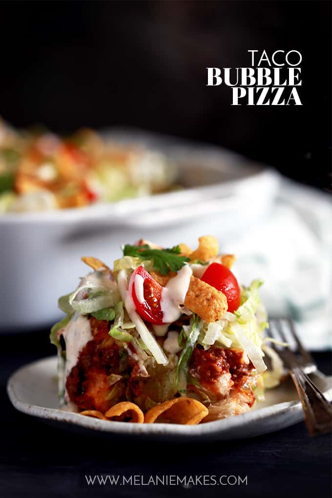 What makes my Taco Bubble Pizza a dinner favorite?  Topped with all the usual taco suspects - ground beef, taco sauce, shredded lettuce, tomatoes, green onions - there's also two toppings which make my Taco Bubble Pizza stand out from the crowd.  You'll no doubt love the crunch of corn chips and homemade chipotle yogurt sauce on this mashup recipe.