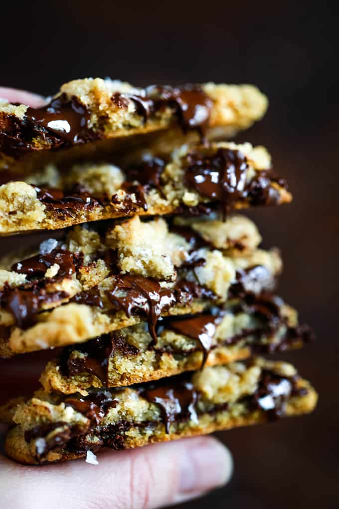 A hand holds a stack of Salted Chocolate Chunk Cookies.